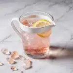 Pink Salt Trick Detox Water with Lemon in White Ceramic Glass