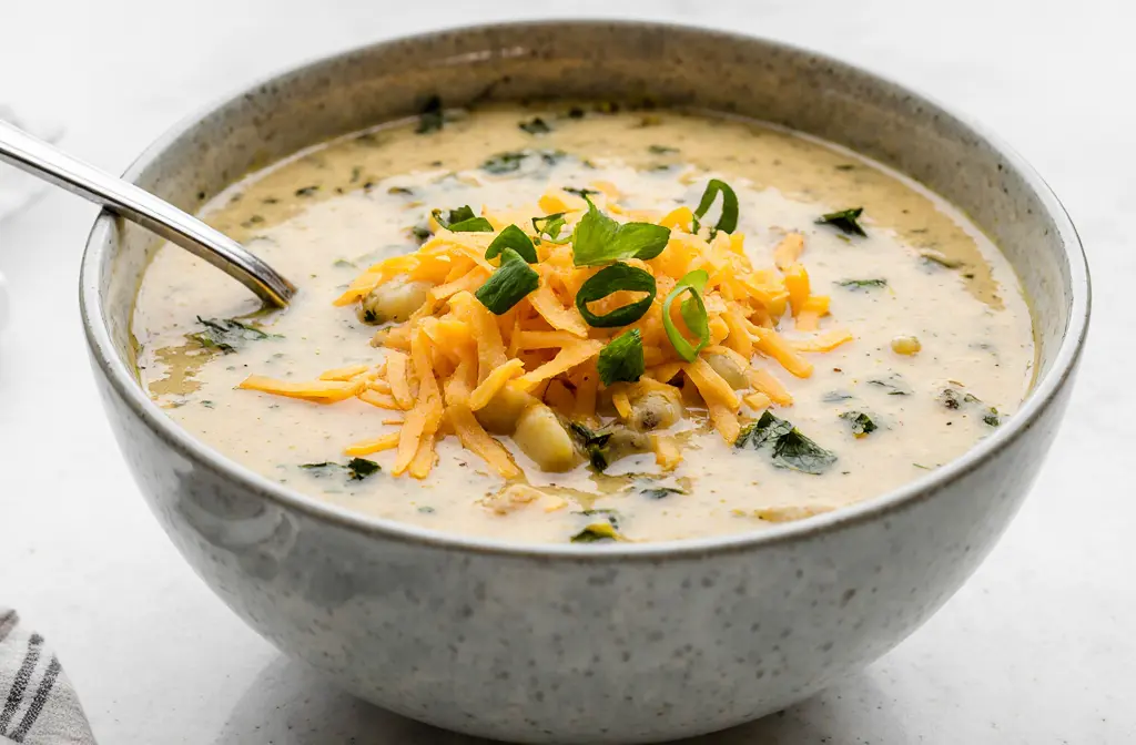 Creamy cheddar garlic herb potato soup in bowl