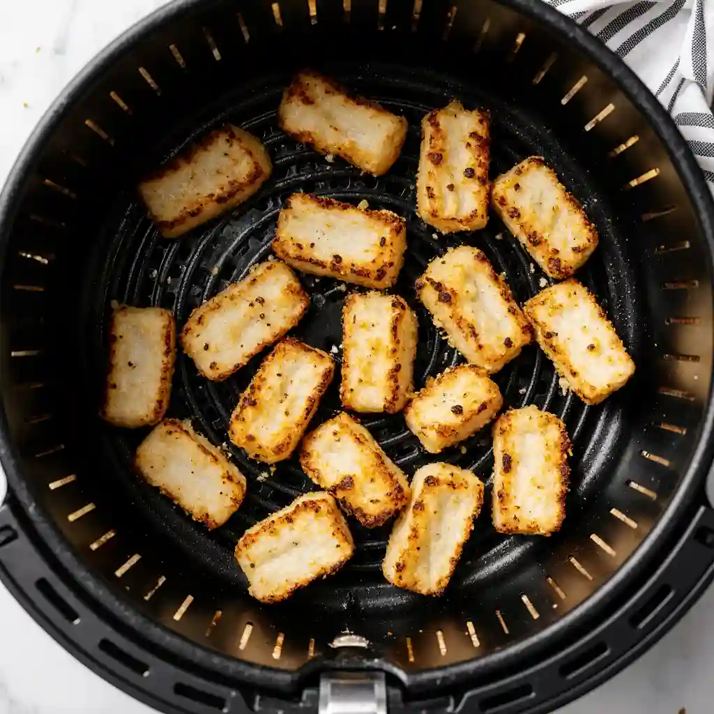 Crispy halloumi fries cooked to golden perfection in an air fryer basket.