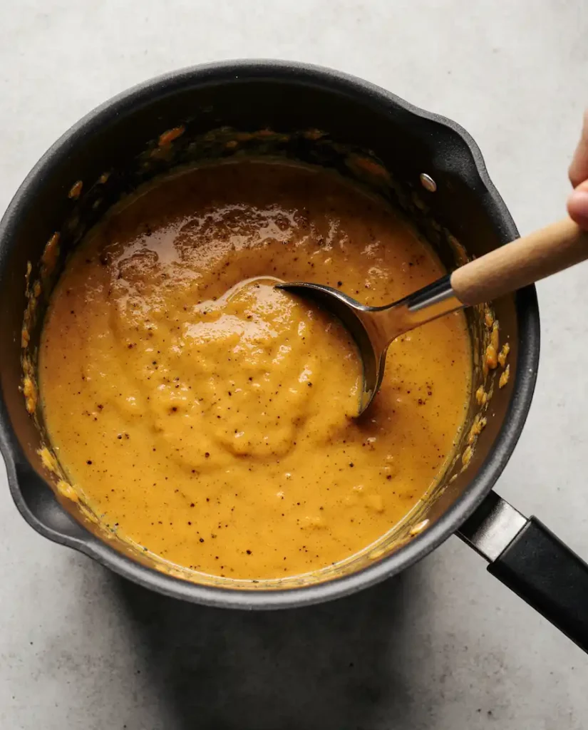 blending-autumn-squash-soup Blending the autumn squash soup with an immersion blender until smooth and creamy.