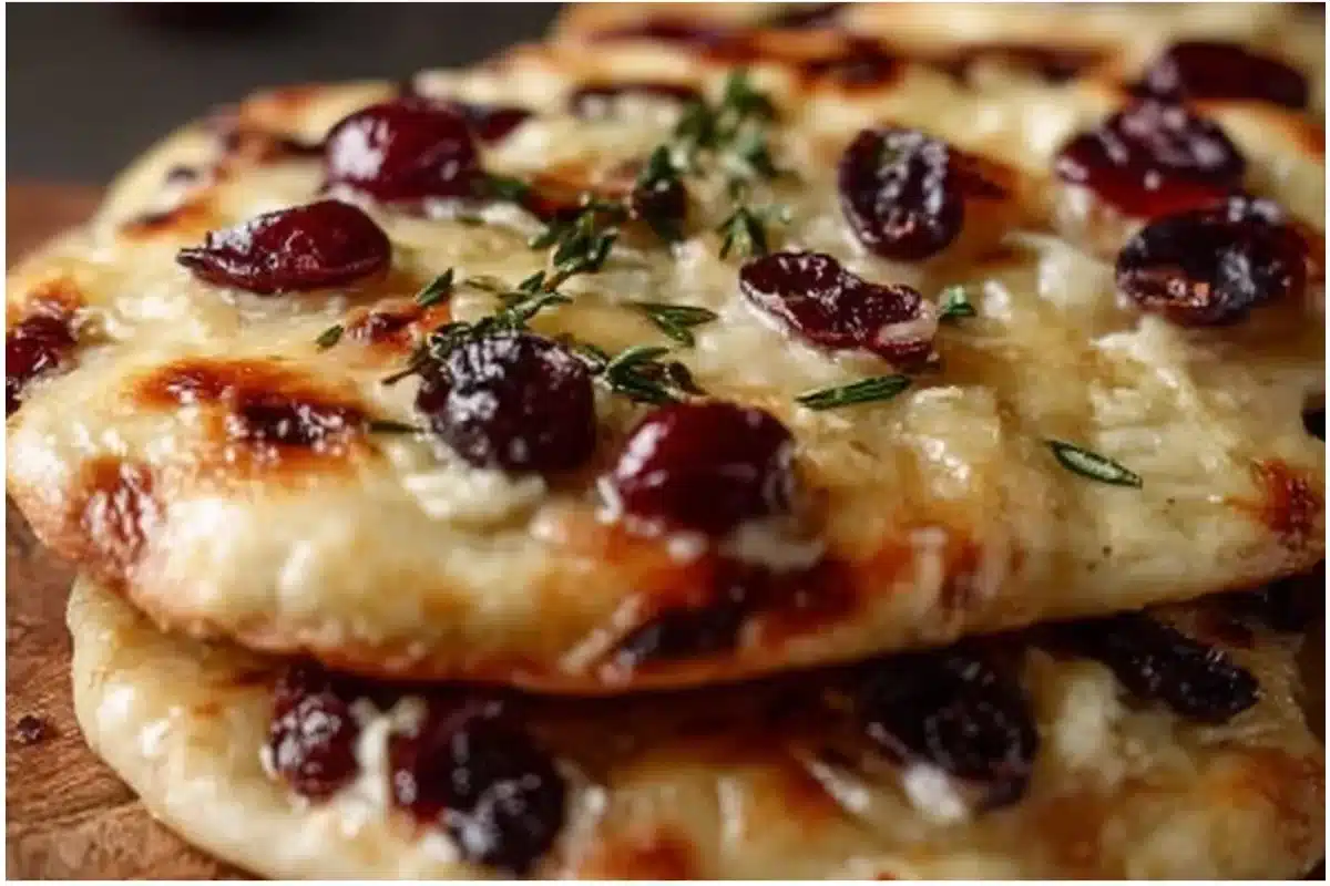 Brie and cranberry flatbreads served on a wooden platter