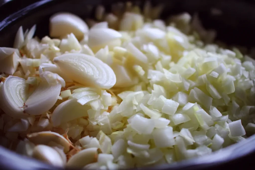 garlic-onion-aromatics-slow-cooker Garlic and onion aromatics in slow cooker base layer