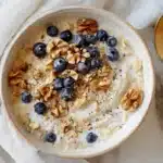 Princess Diana overnight oats recipe in a creamy bowl topped with apple, blueberries, and walnuts. Title attribute