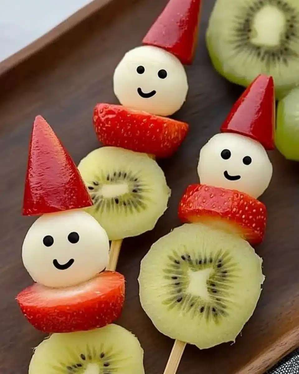 Festive Christmas fruit snowmen skewers made with various fruits for holiday fun.