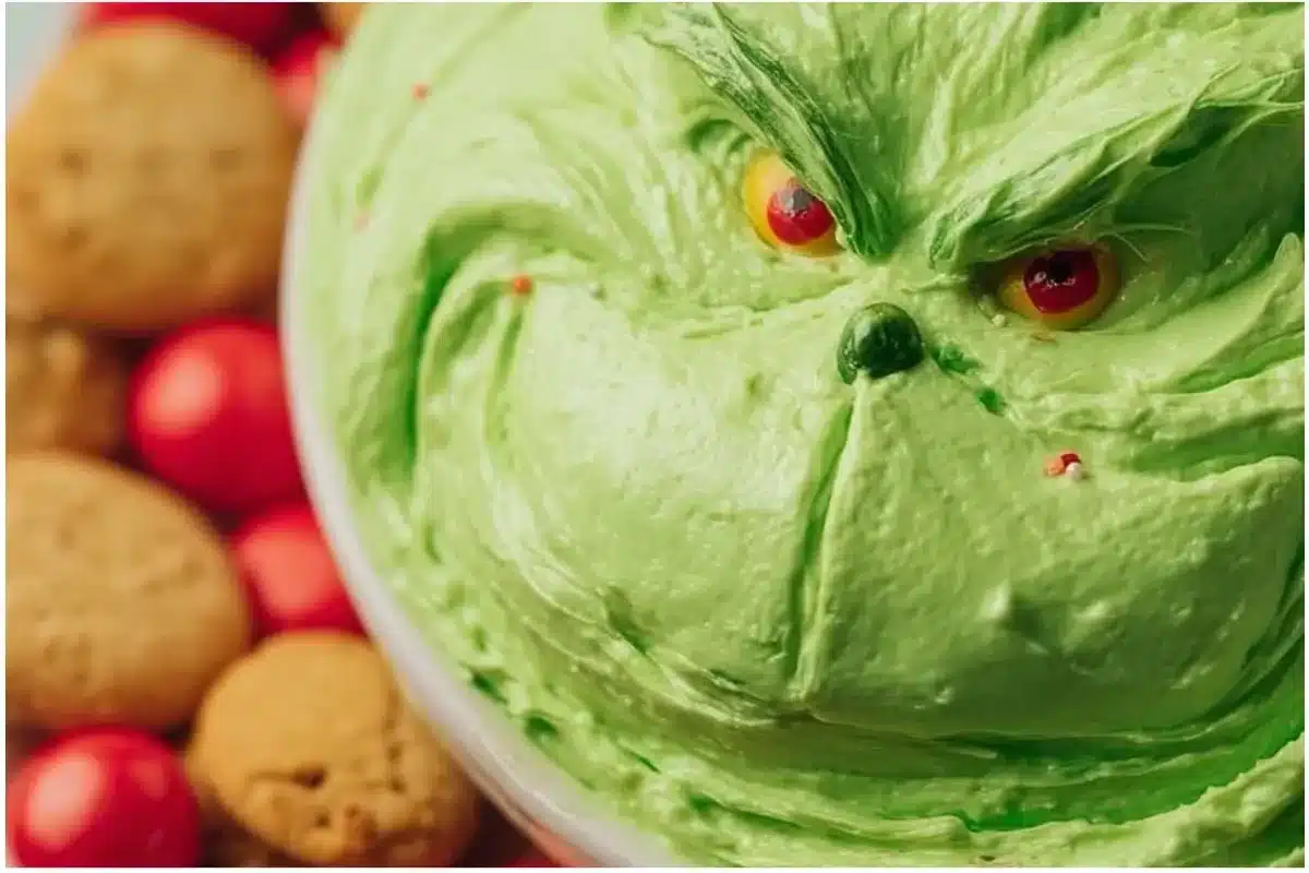 Festive Grinch Dip served in a bowl with holiday decorations.
