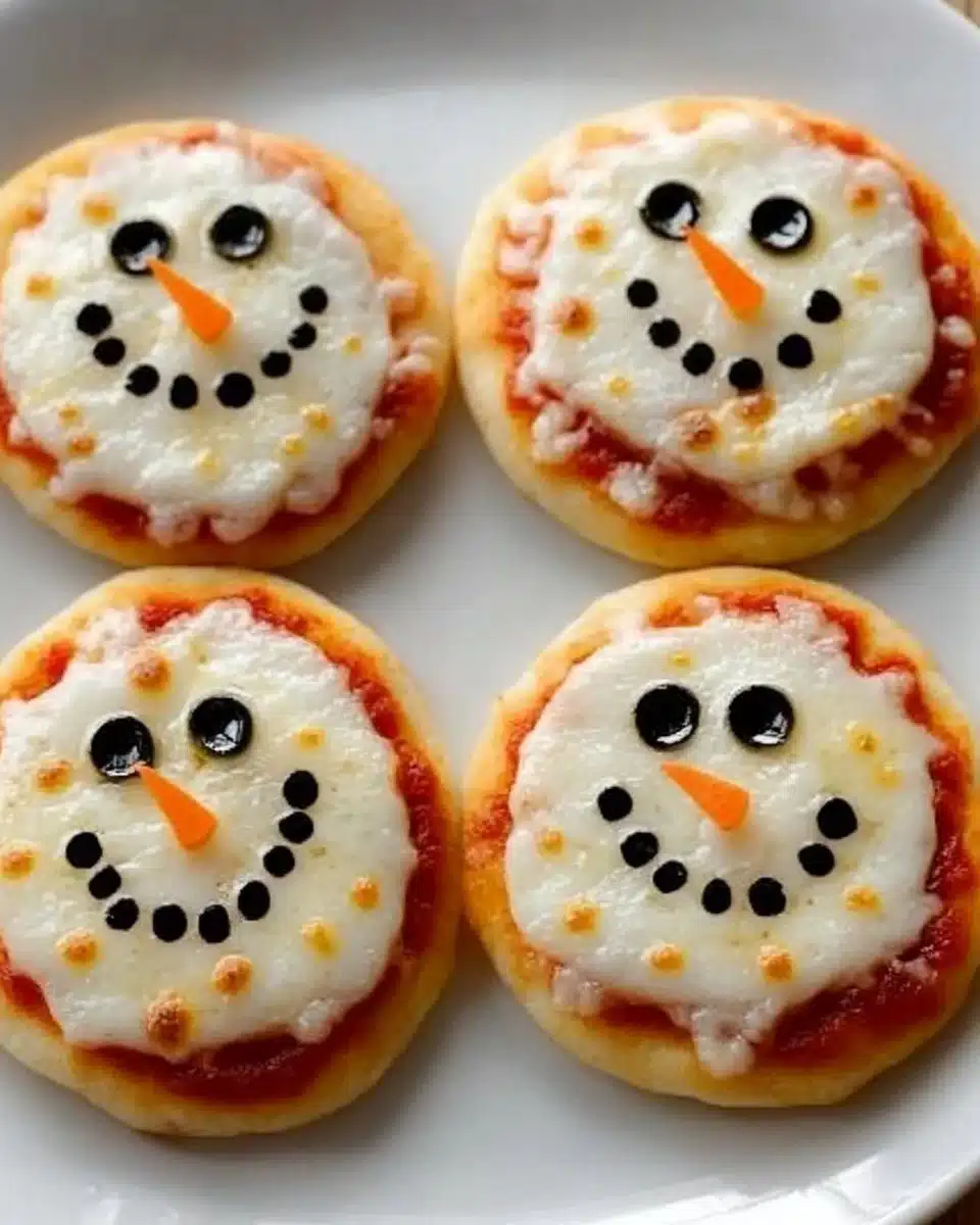 Mini Christmas snowman pizzas decorated with toppings for holiday fun
