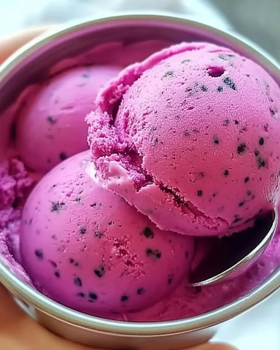 Delicious bowl of dragon fruit ice cream with vibrant pink color and toppings