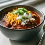 Best Chili Recipe (Homemade, Award-Winning + 5 Variations) 5 Bowl of the best chili recipe with cheddar sour cream and jalapeños on quartz counter