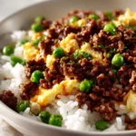 boy kibble recipe ground beef rice bowl with egg and vegetables on white ceramic plate