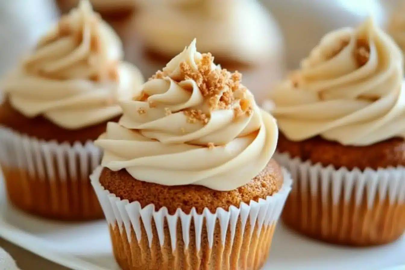 Delicious carrot cake cupcakes with cream cheese frosting on a platter.