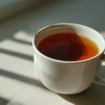 What Is Hojicha: Japan's Roasted Green Tea Explained 13 Cup of amber brown hojicha tea on a light table in a casual home setting