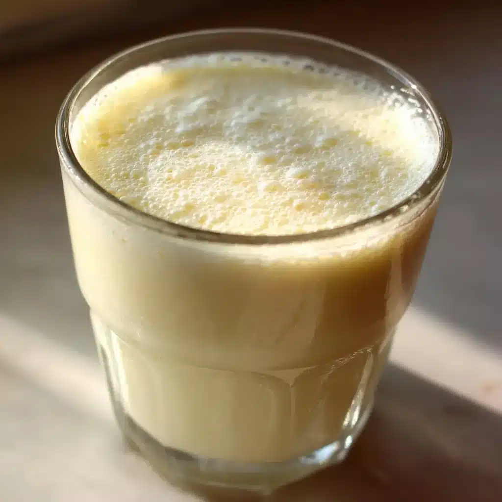 close view of slightly curdled homemade buttermilk from milk in a glass cup
