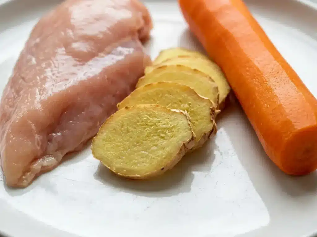 ozempic-nausea-recipe-ingredients Fresh ginger, carrot, and skinless chicken breast for an Ozempic nausea recipe.